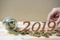 Businessman putting Ã¢â¬Å2019Ã¢â¬Â wooden number with gold coins stack on wooden table. business, investment, retirement planning, fin Royalty Free Stock Photo